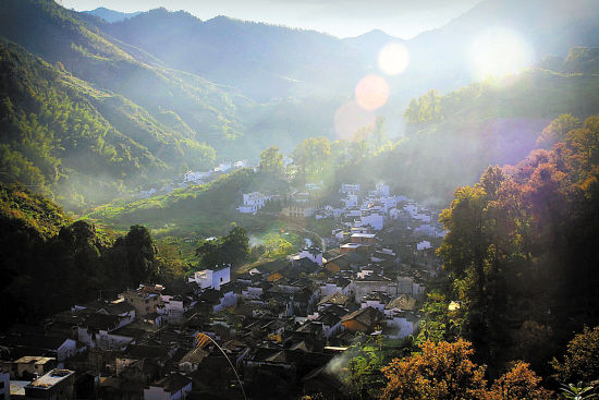 婺源县赋春镇长溪村，阳光映照着满山红叶(新华社供图)