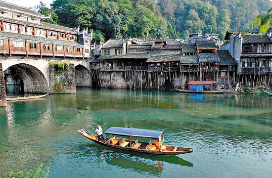 荡舟沱江，欣赏两岸的吊脚楼，是凤凰古城的必选旅游项目